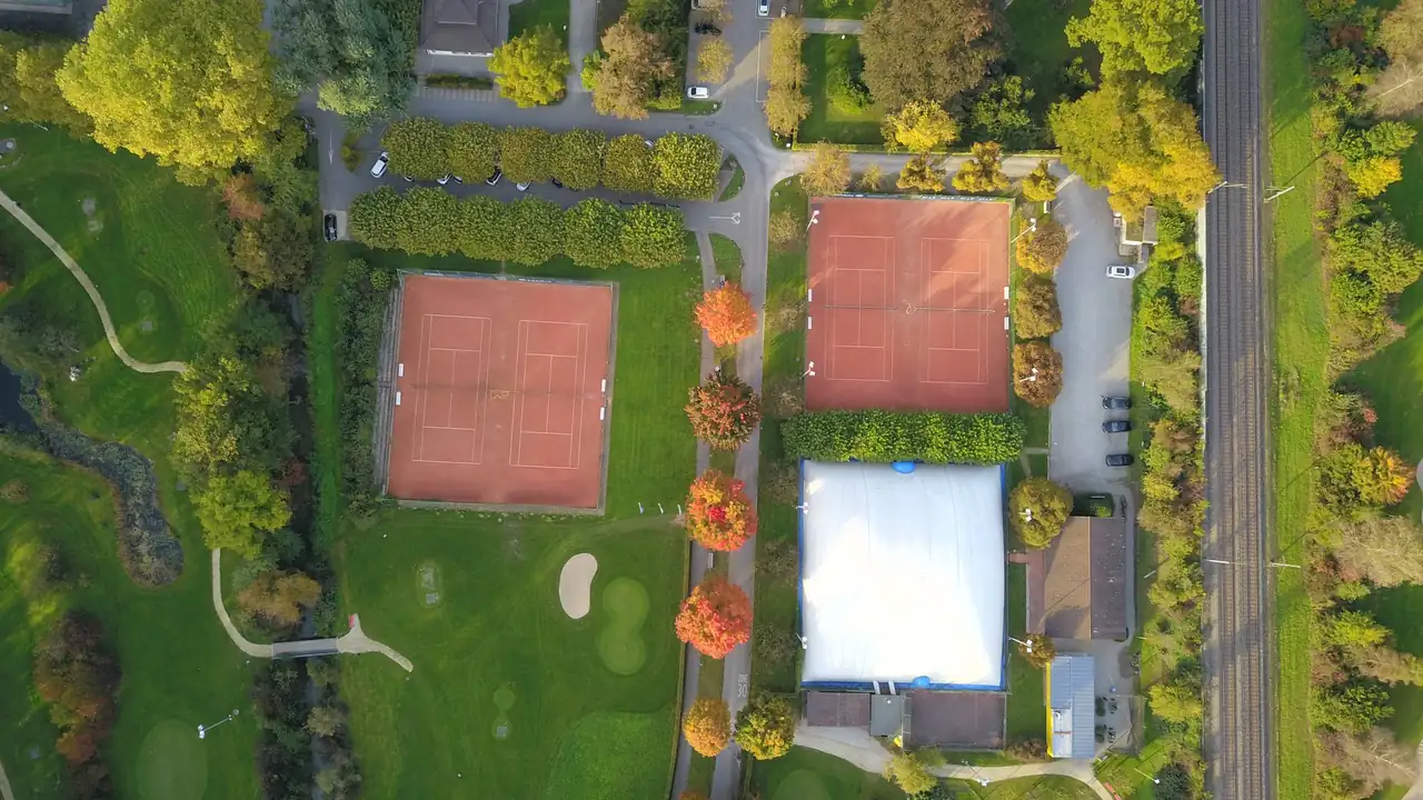 Luftaufnahme der Tennisanlage des TC Bad Schinznach mit Sandplätzen und Traglufthalle
